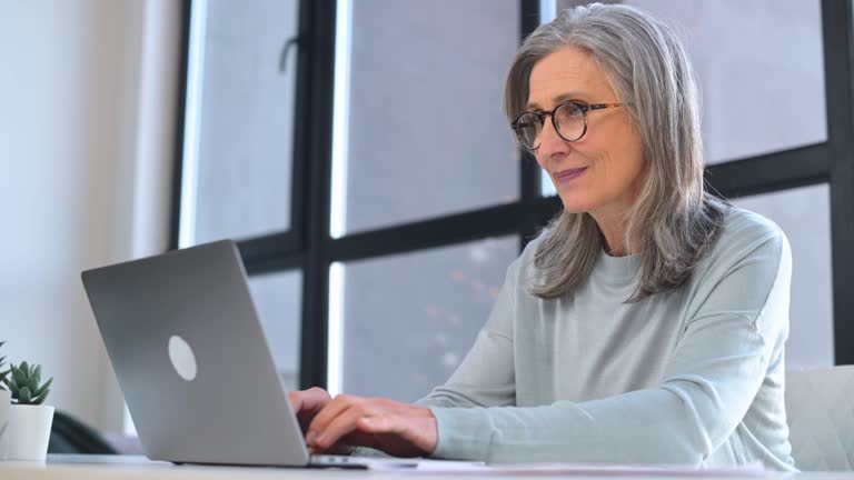 Elderly woman confused by laptop