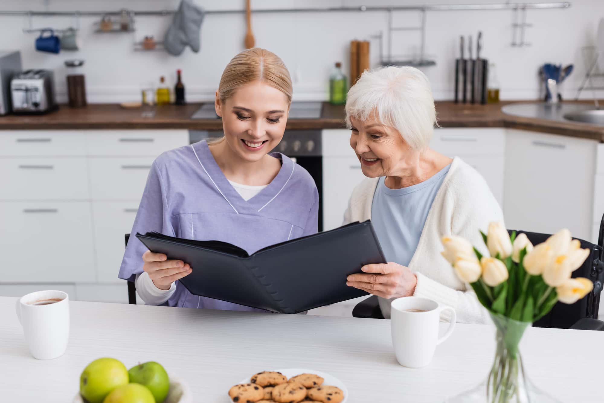 Older adult receiving friendly tech help on a phone or tablet.